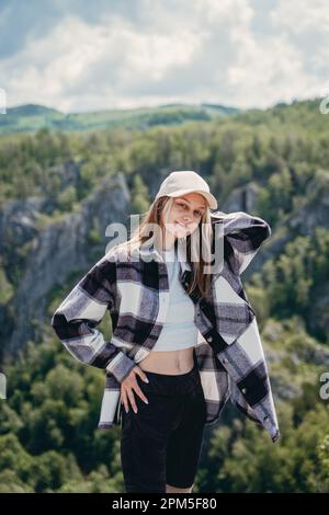 Ein Mädchen mit Mütze, ein kariertes Hemd in einer Berglandschaft Stockfoto