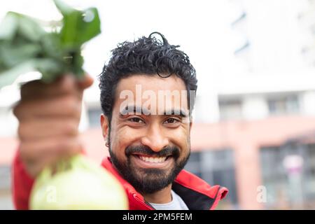 Junger Mann mit roter Jacke und Kohl in der Hand Stockfoto