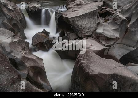 Fluss schneidet durch glatte brasilianische Felsformation Stockfoto