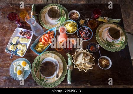 Blick von oben auf den Tisch des gesunden, farbenfrohen Frühstücks auf einem Holztisch Stockfoto