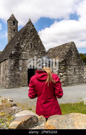 Radfahrerin am St. Kevin Church in Glendalough Stockfoto