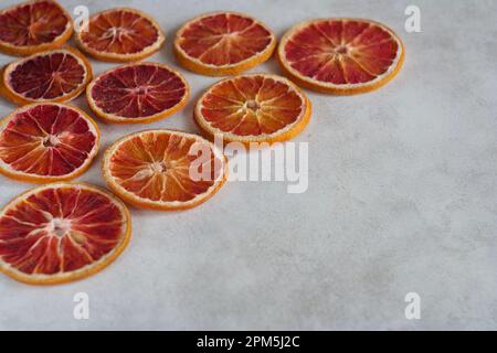 Getrocknete Orangenscheiben liegen auf einem Tisch. Stockfoto