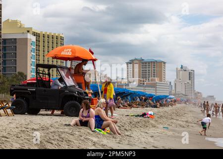 Urlauber genießen die Küste an einem bewölkten Tag in Myrtle Beach, South Carolina, USA. Stockfoto