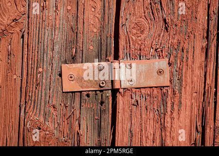 Altes Scharnier auf roten, alten Holzplanken Stockfoto