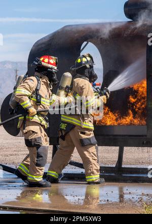 Feuerwehrleute des 355. Zivilingenieurs-Geschwaders Feuerwehr und Rettungsdienst-Flug löschen ein Feuer während einer Übung am Luftwaffenstützpunkt Davis-Monthan, Ariz., 6. April 2023. Mehrere Teams aus zwei Feuerwehrleuten arbeiteten zusammen, um kontrollierte Brände zu löschen. (USA Air Force Foto von Airman William Finn) Stockfoto