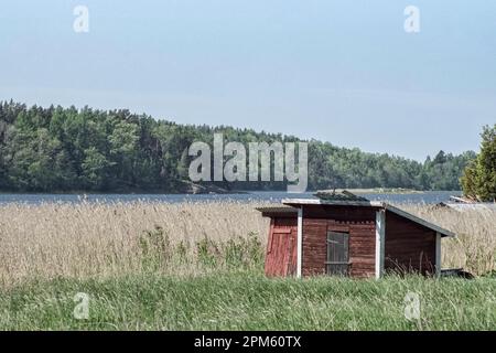 Roter Schuppen auf dem Feld vor dem See Stockfoto