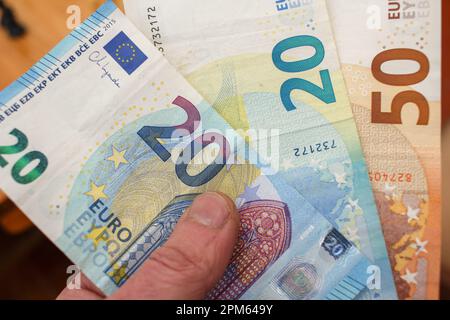 Etwa 20 und 50 Euro Scheine in meiner linken Hand Stockfoto