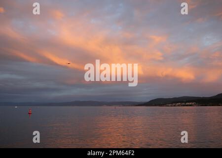 Orange bei Sonnenuntergang über dem kantabrischen Meer in Burela, Spanien Stockfoto