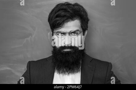 Ein seriöser Schüler, der in der Schule studiert. Junger Lehrer. Lern- und Bildungskonzept. Bildungs- und Lernmenschen-Konzept - Lehrerinnen in der Nähe Stockfoto
