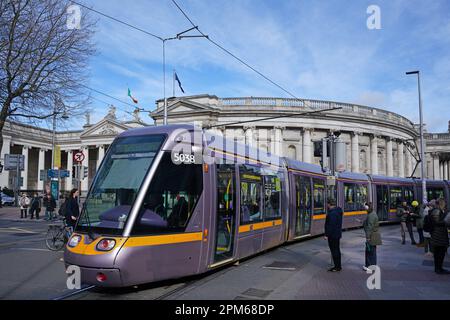 Moderne Straßenbahn in Dublin, bekannt als Luas, mit dem alten Parlamentsgebäude aus dem 18. Jahrhundert im Hintergrund Stockfoto
