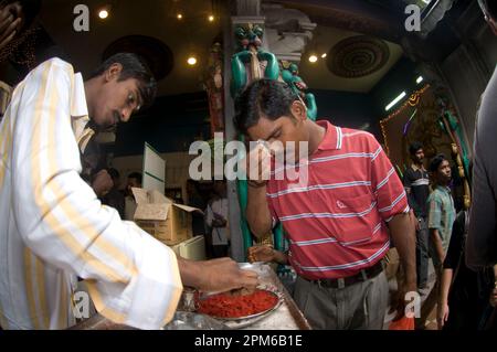 Männliche Anhänger, die bei der Deepavali-Zeremonie weißes Bindi auftragen, Sri Veeramakaliamman-Tempel, Little India, Singapur Stockfoto