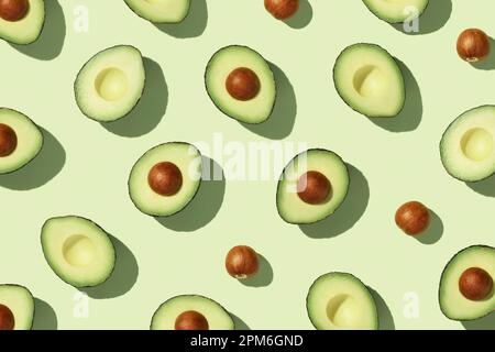 Avocado auf grünem Hintergrund, Draufsicht flach liegend. Sommerfarbe. Minimalkonzept Stockfoto