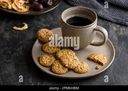 Eine Tasse Kaffee auf einem Teller mit Cornflakes-Keksen. Stockfoto