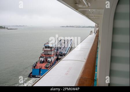 Galveston, Texas - 27. März 2023: Tankschiff neben einem Kreuzfahrtschiff im Hafen von Galveston in Texas. Stockfoto