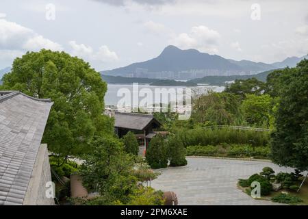 HONGKONG SAR, CHINA. 11. APRIL 2023. Kloster Tsz Shan. Blick über das umliegende Dorf und die Skyline von Hong Kong mit Massenwohnungen. Foto Jayne Stockfoto