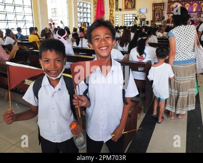 Navotas, Philippinen. 11. April 2023. Die Schulkinder zeigen stolz ihre Flaggen, um dem Relikt von St. Thérèse des Jesuskindes. Die Relikte von St. Therese des Kindes Jesus, auch bekannt als Therese von Lisieux, erreichte die Diözese von Kalookan, die die Städte Malabon, Navotas und den südlichen Teil von Caloocan umfasst. Der erste Halt war in San Lorenzo Ruiz & Companion Martyrs Parish in Navotas City. Es ist der 5. Pilgerbesuch der Reliquie im Land. (Foto: Josefiel Rivera/SOPA Images/Sipa USA) Guthaben: SIPA USA/Alamy Live News Stockfoto