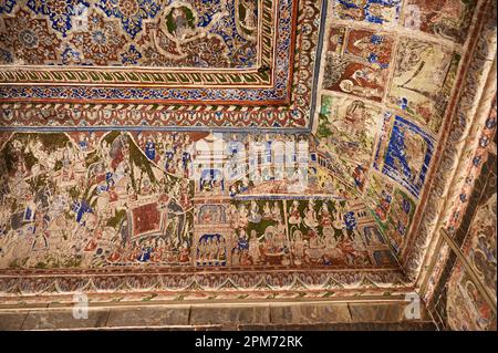 Farbenfrohe mythologische Gemälde und Spiegelarbeiten an der Decke eines kleinen Shani Mandir in Ramgarh, Shekhawati, Rajasthan, Indien Stockfoto