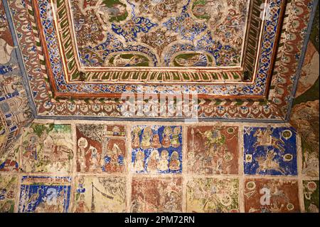 Farbenfrohe mythologische Gemälde und Spiegelarbeiten an der Decke eines kleinen Shani Mandir in Ramgarh, Shekhawati, Rajasthan, Indien Stockfoto