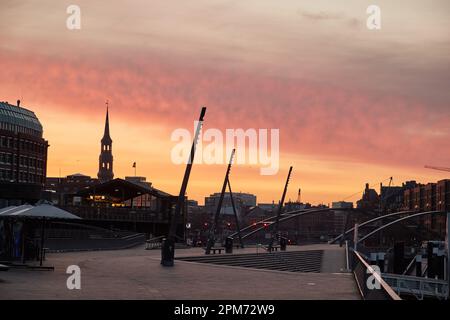 Hamburg, Deutschland. 12. April 2023. Der Himmel über der Baumwall Promenade leuchtet kurz vor Sonnenaufgang rot. Laut Wetterdienst wird es in den nächsten Tagen instabil bleiben. Kredit: Georg Wendt/dpa/Alamy Live News Stockfoto