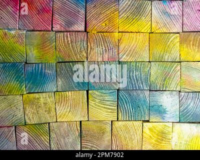 Farbenfrohe Kiefernwürfel. Farbenfrohe Holztexturen. Kiefernstruktur in verschiedenen Farben lackiert. Stockfoto