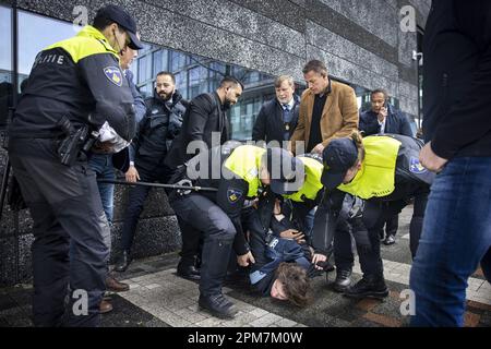 Amsterdam, Niederlande 12. April 2023. AMSTERDAM - Ein Demonstrant wird von der Polizei während des Besuchs des französischen Präsidenten Macron und König Willem Alexander im Quantum Gases & Quantum Information Lab der UVA im Amsterdamer Wissenschaftspark mitgenommen. Das französische Präsidentschaftspaar besucht die Niederlande für zwei Tage. ANP RAMON VAN FLYMEN niederlande Out - belgien Out Credit: ANP/Alamy Live News Stockfoto