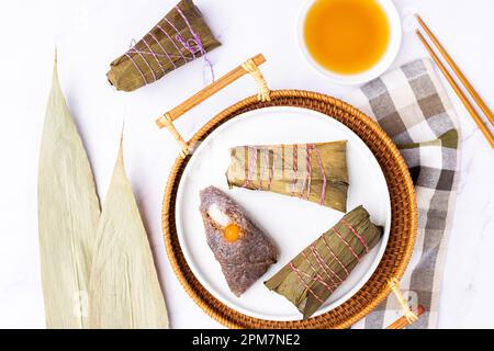 Traditionelles chinesisches Essen für das Drachenbootfestival. Zongzi oder klebrige Reisklöße auf weißem Hintergrund Stockfoto