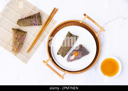 Traditionelles chinesisches Essen für das Drachenbootfestival. Zongzi oder klebrige Reisklöße auf weißem Hintergrund Stockfoto