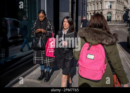 Am 4. April 2023 in London, England, passieren sich drei Frauen in der City of London, auch bekannt als die Square Mile, dem Finanzviertel der Hauptstadt. Stockfoto