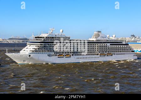 Das luxuriöse Kreuzfahrtschiff „Seven Seas Explorer“ von Regent Cruises verlässt den Kreuzfahrthafen Nr. 1 in St. Petersburg und das Krestovsky St. Petersburg Gazprom-Stadion Stockfoto