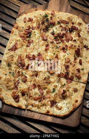 Flammkuchen tarte Flambee rechteckige Pizza mit Speck und Huhn auf Holztisch Hintergrund Stockfoto