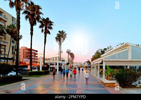Malaga Benalmadena Marina Shopping Walkway am Strand vor einem tiefblauen, rosa Abendhimmel Stockfoto
