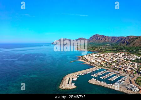 Spanien, Balearen, Mallorca, Bucht von Alcúdia, Colonia de Sant Pere, Stadt am Meer und Hafen, im Hintergrund der Naturpark Península de Llevant und die Berge (Luftaufnahme) Stockfoto