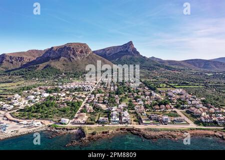 Spanien, Balearen, Mallorca, Bucht von Alcúdia, Colonia de Sant Pere, Stadt am Meer und Hafen, im Hintergrund der Naturpark Península de Llevant und die Berge (Luftaufnahme) Stockfoto