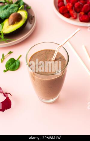 Gesundes Frühstück, Smoothies aus gefrorenen Erdbeeren, Avocado und Banane, Erbsenprotein und Leinensamen, Salatblätter, Smoothies in einem Glas Stockfoto