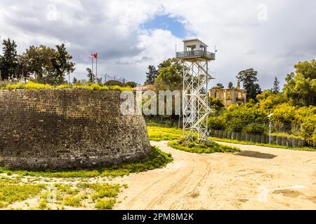 UN-Wachturm in der Pufferzone, die sogenannte Grüne Linie, die 1964 durch das Zentrum von Nikosia verläuft, um die Unruhen zu besänftigen. Lefkoşa Türk Belediyesi, Zypern. UN-Wachturm in der Pufferzone mit der venezianischen Stadtmauer und den Flaggen der türkischen Republik Nordzypern und der Türkei Stockfoto