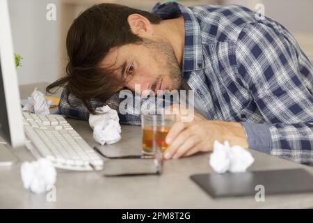 Geschäftsmann trinken von Stress am Arbeitsplatz Stockfoto