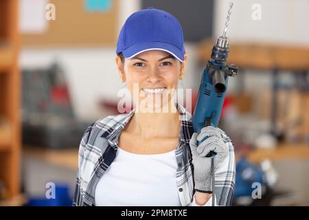 Wunderschöne hispanische Zimmerlerin mit einem Bohrer Stockfoto