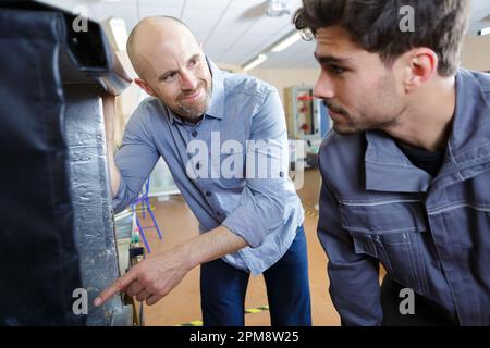 Zwei Arbeiter, die Dämmmaterial anwenden Stockfoto