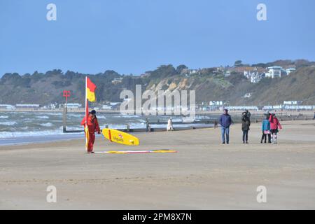 Storm Noa, Bournemouth, Dorset, Vereinigtes Königreich, 12. April 2023, Wetter. Rettungsschwimmer, der am Morgen bei starkem Wind und stürmischen Bedingungen am Strand Warnflaggen aufstellt. Kredit: Paul Biggins/Alamy Live News Stockfoto