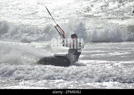 Storm Noa, Boscombe, Bournemouth, Dorset, Vereinigtes Königreich, 12. April 2023, Wetter. Kitesurfer bei starkem Wind und stürmischen Bedingungen am Meer am Morgen. Kredit: Paul Biggins/Alamy Live News Stockfoto