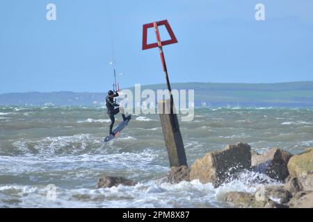 Storm Noa, Boscombe, Bournemouth, Dorset, Vereinigtes Königreich, 12. April 2023, Wetter. Kitesurfer bei starkem Wind und stürmischen Bedingungen am Meer am Morgen. Kredit: Paul Biggins/Alamy Live News Stockfoto