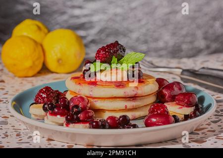 Pfannkuchen mit Honigbanane und gemischten Beeren, garniert mit Minze Stockfoto