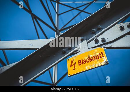 FOTOMONTAGE, Hochspannungsmast mit Schild und Aufschrift Blackout Stockfoto