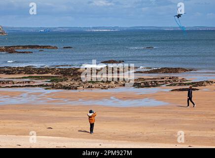 North Berwick, East Lothian, Schottland, Großbritannien. 12. April 2023 Windig am Strand von Milsey Bay in der Küstenstadt. Wind 21 km/h mit möglichen Böen von 42 km/h, Temperatur von etwa 8 Grad Celsius, echtes Gefühl 2 Grad Celsius. Abbildung: Ein Junge nutzt die windigen Bedingungen, um einen Drachen in Form eines Schmetterlings vom Strand zu fliegen. Kredit: Archwhite/alamy Live News. Stockfoto