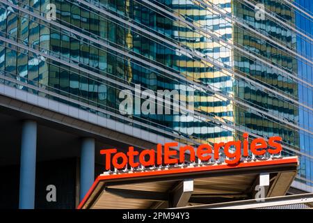 Zeichen einer TotalEnergies-Tankstelle mit einem Glasgebäude im Hintergrund. Stockfoto