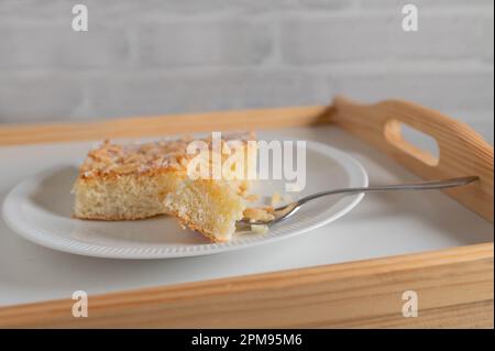 Butterkuchen mit Mandeln und Zuckerfüllung. Traditioneller deutscher Hefekuchen auf einem Teller Stockfoto