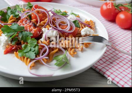 Fitnessessen mit Vollkornpasta, Gemüse und proteinreichem Hüttenkäse auf einem Teller Stockfoto