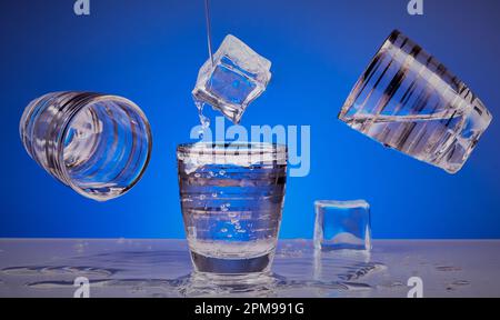 Wodka-Shot-Gläser mit Eiswürfeln mit blauem Hintergrund. Stockfoto