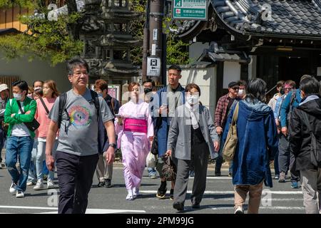 Kyoto, Japan - 28. März 2023: Ein Paar in Kimonos überquert die Straße in Kyoto, Japan. Stockfoto