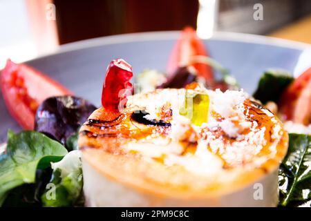 Gummibären, die mit Ziegenkäse auf einem Esstisch spielen Stockfoto